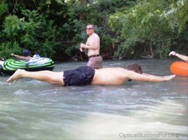 Man Using Human Raft Optical Illusion